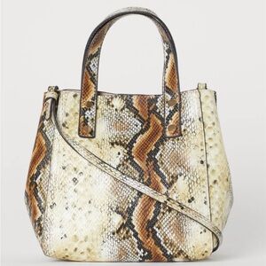 Mini shopper with two handles at the top, a narrow, detachable shoulder strap